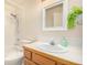 Cozy bathroom with shower-tub combo, wood vanity and white tile surround at 2072 Skylark Ct, Longmont, CO 80503