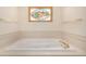 Soaking tub with gold fixtures and stained glass window in remodeled primary bathroom at 2072 Skylark Ct, Longmont, CO 80503