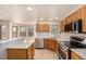 Well-lit kitchen featuring wood cabinets, stainless steel appliances, tile floors and a sunlit breakfast nook at 2072 Skylark Ct, Longmont, CO 80503