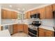 A kitchen featuring wood cabinets, stainless steel appliances, tile flooring, and modern countertops at 2072 Skylark Ct, Longmont, CO 80503