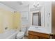 Full bathroom with a white tub, tiled yellow walls, and a vanity with a sink at 7659 S Rosemary Cir, Englewood, CO 80112