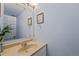 Powder room featuring blue walls, a neutral countertop, and decorative accents at 7659 S Rosemary Cir, Englewood, CO 80112