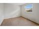 Simple bedroom featuring neutral carpeting, white walls, and a bright window at 7659 S Rosemary Cir, Englewood, CO 80112