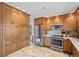 Spacious kitchen features stainless steel appliances, custom cabinets, and tiled floors at 7659 S Rosemary Cir, Englewood, CO 80112