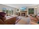 Bright living room with a brick fireplace and large windows creating a relaxing atmosphere at 7659 S Rosemary Cir, Englewood, CO 80112