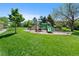 Community playground with green play structure provides fun for children at 7659 S Rosemary Cir, Englewood, CO 80112