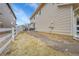 Backyard with a paved seating area, some dead grass, and a path leading to the side of the house at 23601 E Mississippi Cir, Aurora, CO 80018