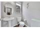 Powder room featuring a pedestal sink, toilet, modern lighting and decor at 23601 E Mississippi Cir, Aurora, CO 80018