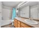 Bathroom featuring double sinks, white shower and tub with blue shower curtain at 23601 E Mississippi Cir, Aurora, CO 80018