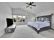 Spacious bedroom with ceiling fan, TV, many windows, and dark wooden bed frame at 23601 E Mississippi Cir, Aurora, CO 80018