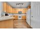 Bright kitchen featuring wood-look floors, wooden cabinets, and white appliances at 23601 E Mississippi Cir, Aurora, CO 80018