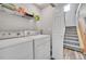 Laundry area with washer, dryer, storage shelf, and staircase at 23601 E Mississippi Cir, Aurora, CO 80018