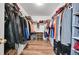 Walk-in closet with wood floor and packed with hanging clothes and shelving for optimal storage at 23601 E Mississippi Cir, Aurora, CO 80018