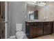 Bathroom showcases a double sink vanity with granite countertop, framed mirror, and modern toilet at 23744 E Ida Pl # E, Aurora, CO 80016