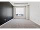 Bright bedroom with a neutral carpet, features a large window for ample natural light, and an accent wall at 23744 E Ida Pl # E, Aurora, CO 80016