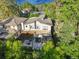 Aerial view of modern home with covered patio, lush backyard, and neighborhood tennis courts at 445 Forest St, Denver, CO 80220
