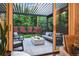View of covered patio with outdoor seating, modern firepit, and lush green backyard at 445 Forest St, Denver, CO 80220