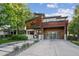 Stunning modern home with wood accents, a glass garage door, professional landscaping, and a spacious driveway at 445 Forest St, Denver, CO 80220