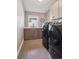 Functional laundry room with front-load machines, sink, and ample cabinet space at 445 Forest St, Denver, CO 80220