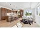 Open kitchen with island, stainless steel appliances, wood cabinets, and adjacent dining area at 960 Quitman St, Denver, CO 80204