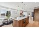 Open-concept kitchen and dining area with stainless steel appliances, wood cabinetry, and quartz countertop at 960 Quitman St, Denver, CO 80204