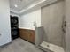 Functional laundry room with stacked washer/dryer, sink with modern faucet, tiled shower, and neutral colors at 960 Quitman St, Denver, CO 80204
