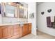 Bathroom featuring wood cabinets, dual sinks, mirrors and neutral decor at 23753 E 155Th Way, Brighton, CO 80603