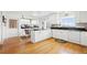 Bright kitchen with white cabinetry, black countertops, hardwood floors, and modern appliances at 23753 E 155Th Way, Brighton, CO 80603