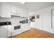 Clean kitchen featuring white cabinets, black countertops, and hardwood floors at 23753 E 155Th Way, Brighton, CO 80603