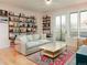 Bright living room features hardwood floors, comfortable seating, floor to ceiling bookshelves, and balcony access at 3701 Arapahoe Ave # 304, Boulder, CO 80303