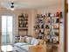 Bright living room features hardwood floors, comfortable seating, floor to ceiling bookshelves, and balcony access at 3701 Arapahoe Ave # 304, Boulder, CO 80303