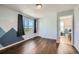 Bedroom with hardwood floors, mountain art, and a window with dark curtains at 5624 Killdeer St, Brighton, CO 80601