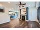 Open-concept living room with a fireplace, modern ceiling fan, and access to the kitchen at 5624 Killdeer St, Brighton, CO 80601