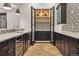 Basement wet bar area with wine storage, tile backsplash, and wood-look floors at 2511 S Columbine St, Denver, CO 80210