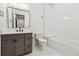 Bright bathroom with gray vanity, tub, and white tile features modern fixtures at 2511 S Columbine St, Denver, CO 80210