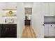 Hallway featuring a bar area and view into kitchen area, hardwood flooring, and modern lighting at 2511 S Columbine St, Denver, CO 80210