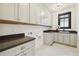 Well-lit laundry room with custom cabinetry, black countertops, and modern fixtures at 2511 S Columbine St, Denver, CO 80210