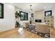 Cozy living room with modern lighting fixture, tile fireplace, and neutral armchairs with a geometric rug at 2511 S Columbine St, Denver, CO 80210