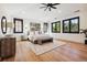 Bright main bedroom featuring hardwood floors, white walls, black window frames, and a large patterned rug at 2511 S Columbine St, Denver, CO 80210