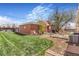 Spacious backyard with a brick garage, patio, mature trees, and a well-maintained lawn at 3254 S Bannock St, Englewood, CO 80110