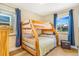 Cozy bedroom with wood frame bunkbeds and blue curtains framing bright windows at 3254 S Bannock St, Englewood, CO 80110