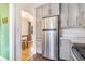 Modern kitchen featuring updated appliances, white subway tile backsplash, and gray cabinets at 3254 S Bannock St, Englewood, CO 80110
