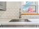 Modern kitchen with white tile backsplash, stainless steel sink, and gray cabinets at 3254 S Bannock St, Englewood, CO 80110