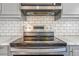 Close up view of an updated stainless steel cooktop with tile backsplash in the kitchen at 3254 S Bannock St, Englewood, CO 80110