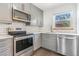 Bright kitchen features stainless steel appliances, tile backsplash, and gray cabinetry at 3254 S Bannock St, Englewood, CO 80110