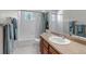 Bright bathroom featuring a tub with shower, white tile, and a wooden vanity with neutral countertop at 6633 E 166Th Pl, Brighton, CO 80602