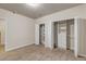 Neutral carpeted bedroom with dual closets featuring extensive built-in shelving and drawers at 6633 E 166Th Pl, Brighton, CO 80602