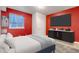 Bedroom featuring red walls, a large flat screen TV, and a modern bed frame at 6633 E 166Th Pl, Brighton, CO 80602