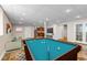Spacious basement game room with a pool table, living area, and kitchenette in the background at 6633 E 166Th Pl, Brighton, CO 80602