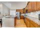 Well-lit kitchen with granite countertops, stainless steel appliances, and wood cabinets at 6633 E 166Th Pl, Brighton, CO 80602
